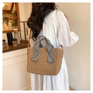 Détail du sac fourre-tout en paille avec poignée ruban et bandoulière en cuir souple