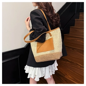 Straw tote bag detail showing the woven texture and brown leather straps on a model