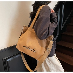 Detail of khaki canvas tote with adjustable shoulder strap and metal hardware