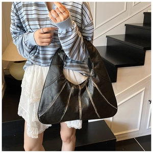 Detail of black leather hobo bag featuring diagonal stitching and large capacity design