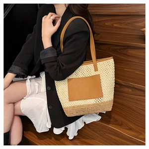 Detail of handmade straw tote bag with cutout weave and premium brown leather straps