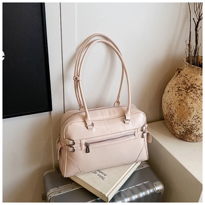Detailed view of pink tote bag with front pocket and straps on a travel suitcase