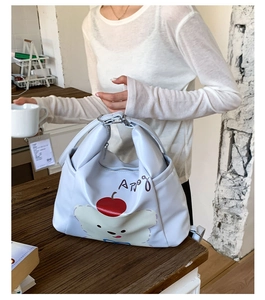 Détail du sac cabas en cuir blanc avec imprimé ours mignon et fermeture éclair en métal