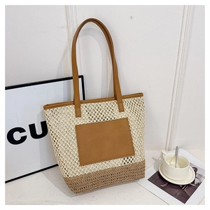 Close-up of contrast woven straw tote bag with brown leather handles and front pocket