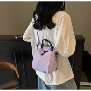 Detail of purple waterproof nylon mini backpack with textured rope handle on a model