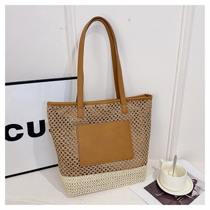 Close-up of contrast woven straw tote bag with brown leather pocket and straps detail