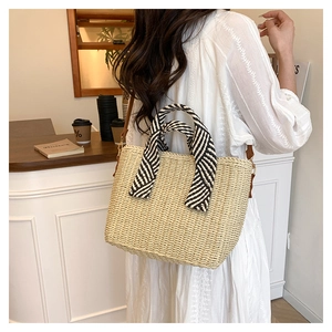 Sac fourre-tout en paille avec poignée en sangle rayée sur modèle dans un café