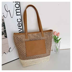 Detail of two-tone woven straw tote bag with brown PU leather pocket and straps