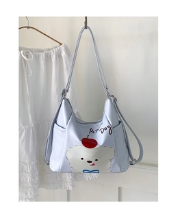 Détail du sac cabas bleu clair avec motif ours et poches latérales pratiques