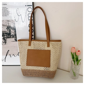 Detail of hand-woven straw tote with brown leather base and pocket for summer vacations