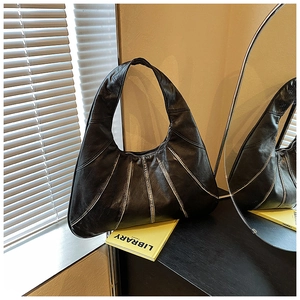 Detail of black hobo bag with white radial stitching and spacious half-moon structure