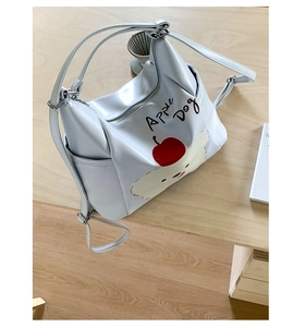 Détail du sac bleu clair Apple Dog avec illustration de chiot et bretelles réglables