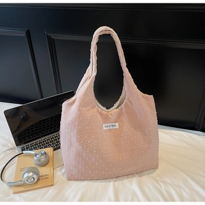 Detail of pink canvas tote bag with polka dot texture and Nuo si Man label