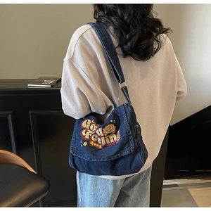 Detail of blue denim tote featuring embroidered stars and Good Feeling Good text