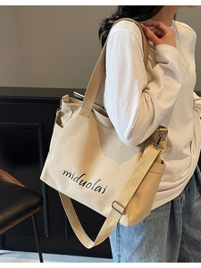 Minimalist beige canvas tote bag with adjustable shoulder strap and large capacity