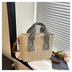 Détail du sac cabas en paille avec poignées en sergé et bandoulière en cuir marron