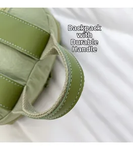 Detail of light green backpack showing durable reinforced top handle and neat stitching
