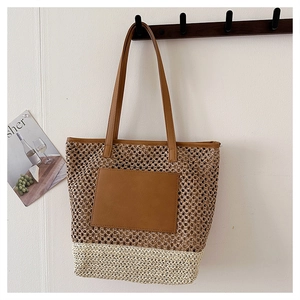Detail of dual-tone straw tote bag showing contrast textures and brown leather shoulder straps