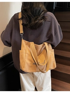 Large khaki canvas tote bag with adjustable straps and side pocket for daily commute