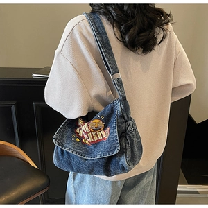 Detail view of retro denim tote bag featuring American style cartoon embroidery and pleats