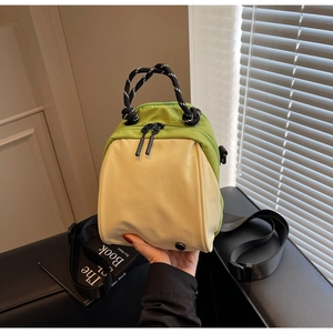 Detail of contrast-color mini shell bag showing braided rope handle and nylon material
