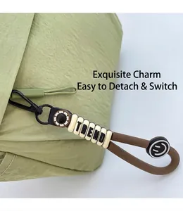 Detail of trendy bag charm with Trend beads and Smile silicone strap on green nylon fabric