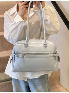 Light blue faux leather Boston bag with metallic zipper and decorative straps in retro style