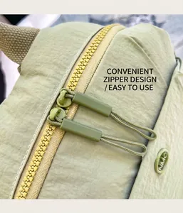 Detail of light green nylon backpack with durable dual zippers and long pull tabs