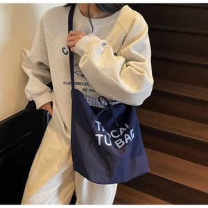 Détail du grand sac cabas en toile marine avec cordon et doublure à carreaux bleus