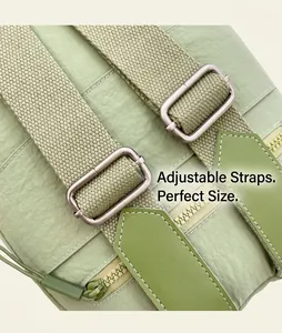 Detail view of the adjustable shoulder strap on a light green nylon commuter backpack