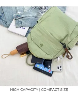 Flat lay macro of the light green nylon backpack with diverse everyday items inside