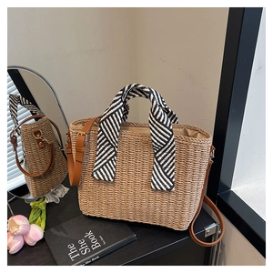 Détail du sac cabas en paille tissée avec poignée foulard rayé et bandoulière en cuir