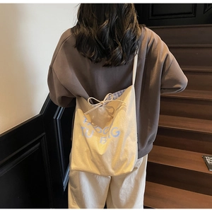Détail du sac fourre-tout en toile avec nœud et doublure intérieure à carreaux bleus