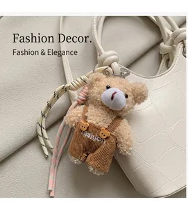 Close-up of a plush bear bag charm wearing corduroy overalls with fashion embroidery