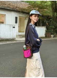 Detail der Crossbody-Flaschentasche mit braunem Stoff und pinker Kordelzugtasche