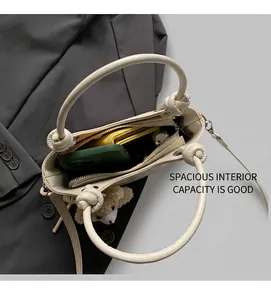 Overhead view showing the spacious interior of an off-white leather bucket bag for women