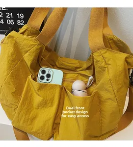 Close-up of yellow nylon tote bag featuring functional dual front pockets for storage
