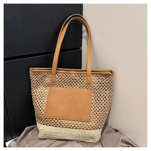 Detail of two-tone woven straw tote bag with brown leather pocket and slim shoulder straps