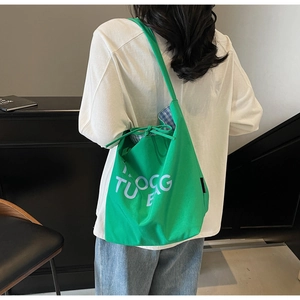Détail du sac cabas en toile verte avec cordon de serrage et doublure à carreaux