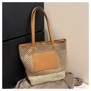 Detail of woven straw tote bag featuring contrast PU leather handles and patchwork design