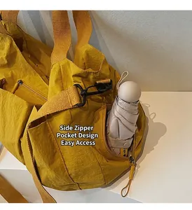 Detail of a bright yellow functional nylon bag showing side zipper pocket with an umbrella