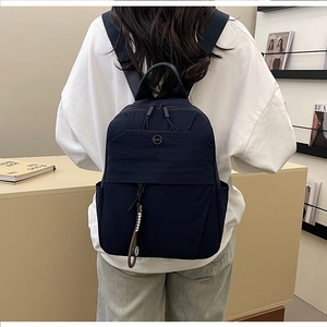 Deep blue nylon backpack detail showing the sleek texture and premium NMC logo patch