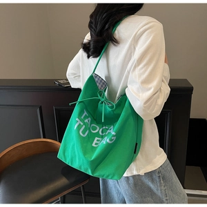 Détail du sac cabas en toile verte avec fermeture à cordon et doublure à carreaux bleus