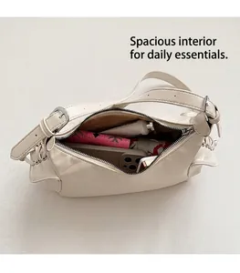 Intérieur spacieux du sac à bandoulière en cuir blanc crème montrant sa grande capacité
