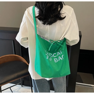 Détail du grand sac cabas vert en toile avec nœud coulissant et lettrage FAOCAI BAG
