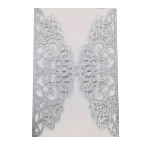 Silver glitter laser-cut invitation card with elegant vine patterns on white background