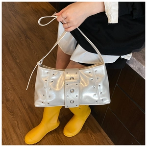 Détail du sac argenté métallisé avec rivets Y2K et large sangle à trois œillets