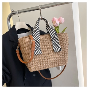 Détail du sac cabas en paille tissé avec poignée rayée noir et blanc et bandoulière