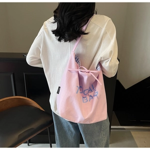 Détail du grand cabas en toile rose montrant la capacité et l'imprimé bleu au dos