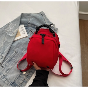 Red waterproof nylon mini backpack featuring a unique black and white rope knot handle